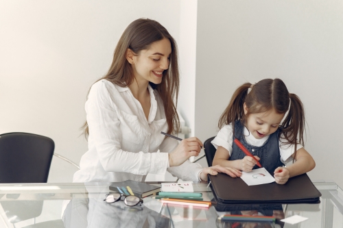 tutor helping student with work and smiling