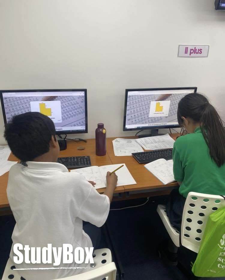 Two students working through 11 Plus practice on screen and paper at StudyBox Wallington